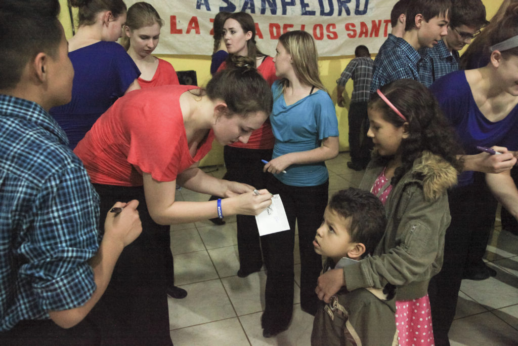 Boulder Suzuki Strings students autograph postcards for audience in Costa Rica